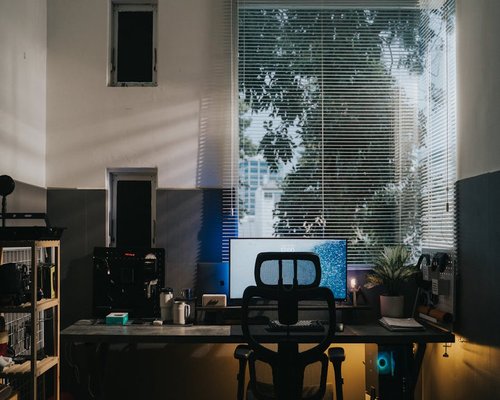 A well lit home office setup with ergonomic chair by a window in Spain